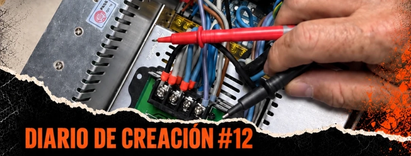 Mano con las sondas de un multímetro sobre la caja de conexiones. Diario de creación #12: La fragilidad de la luz, de El Diablo Cojuelo.